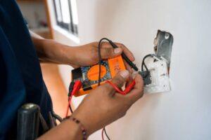 electrician-fixing-an-electrical-outlet-and-measuring-the-voltage