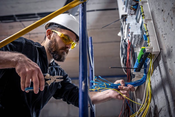 male-electrician-works-in-a-switchboard-with-an-electrical-connecting-cable