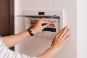 circuit-breaker-board-displays-many-switches-a-finger-is-about-to-turn-it-back-on