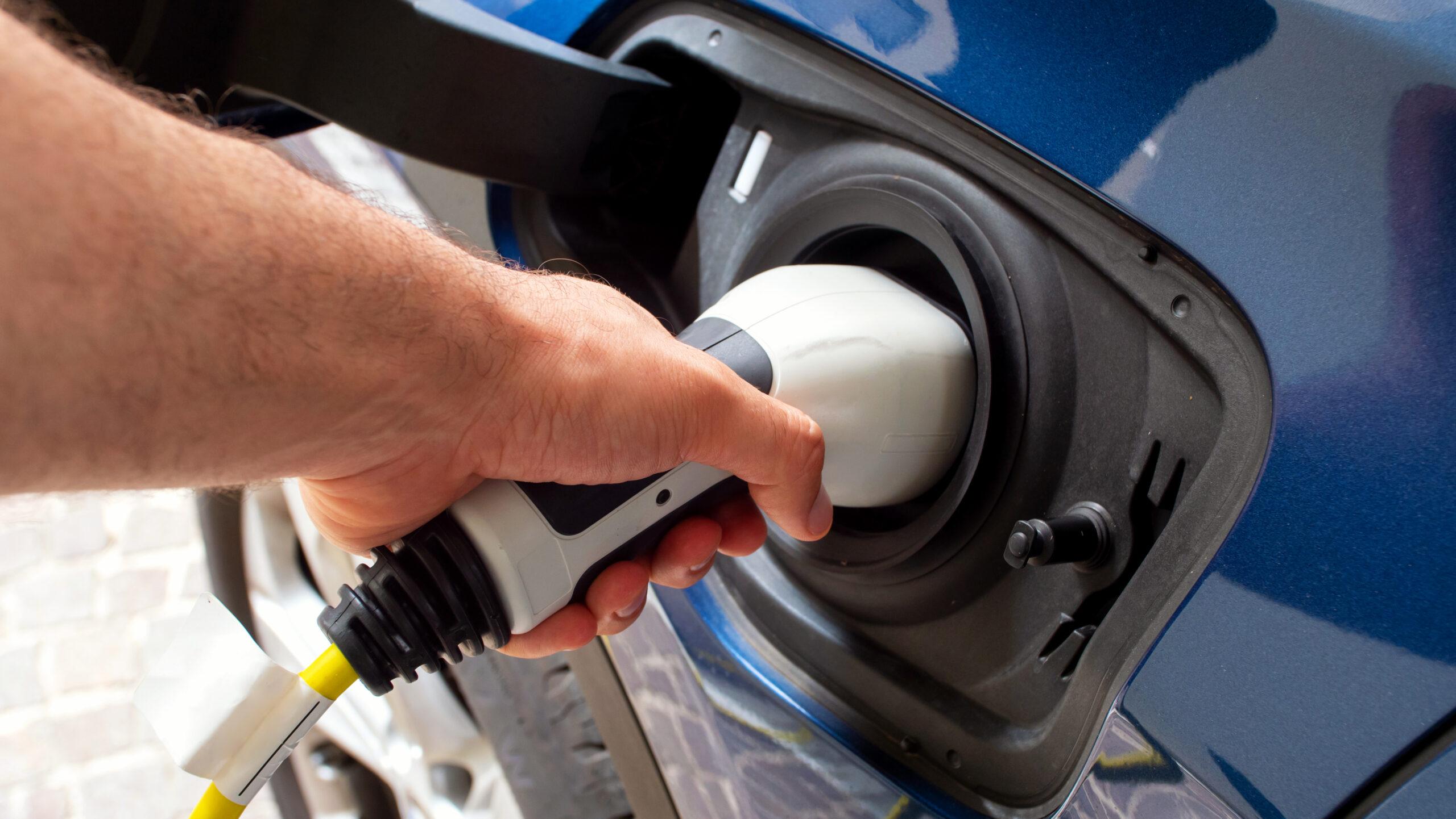 The electric car charger plugged in to the socket.The modern electric car charging the battery.