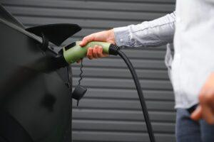 a man charges an electric car.
