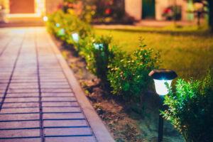 Decorative Small Solar Garden Light, Lanterns In Flower Bed In Green Foliage. Garden Design. Solar Powered Lamps In Row