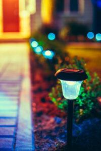 Small Solar Garden Light, Lanterns In Flower Bed. Garden Design. Solar Powered Lamp